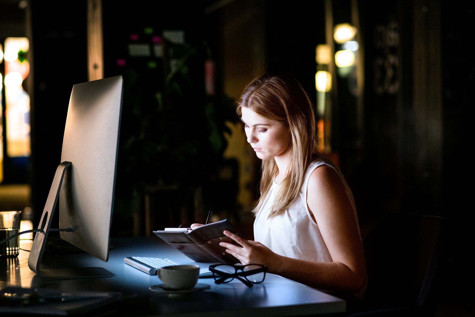 Businesswoman in her office at night working late.