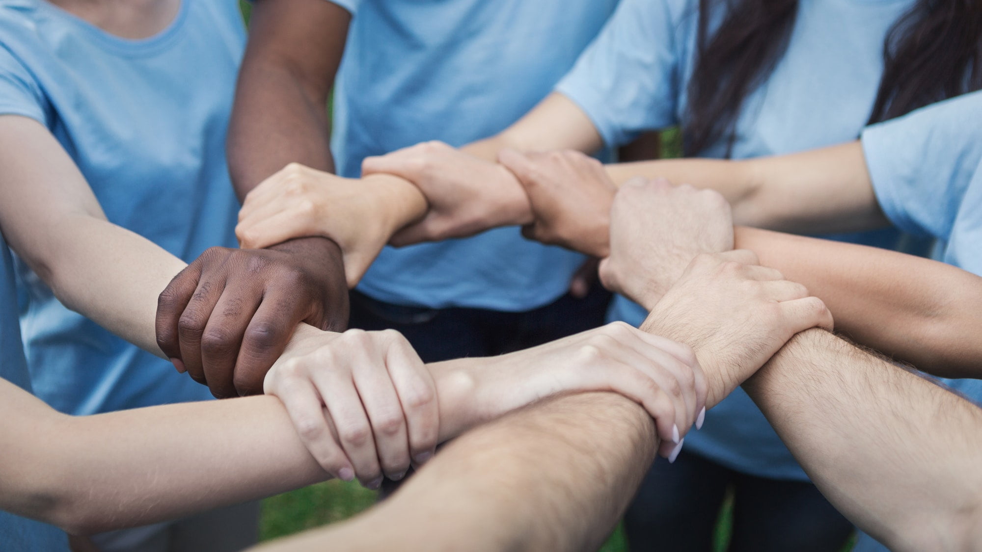 Hands of young people joined in circle