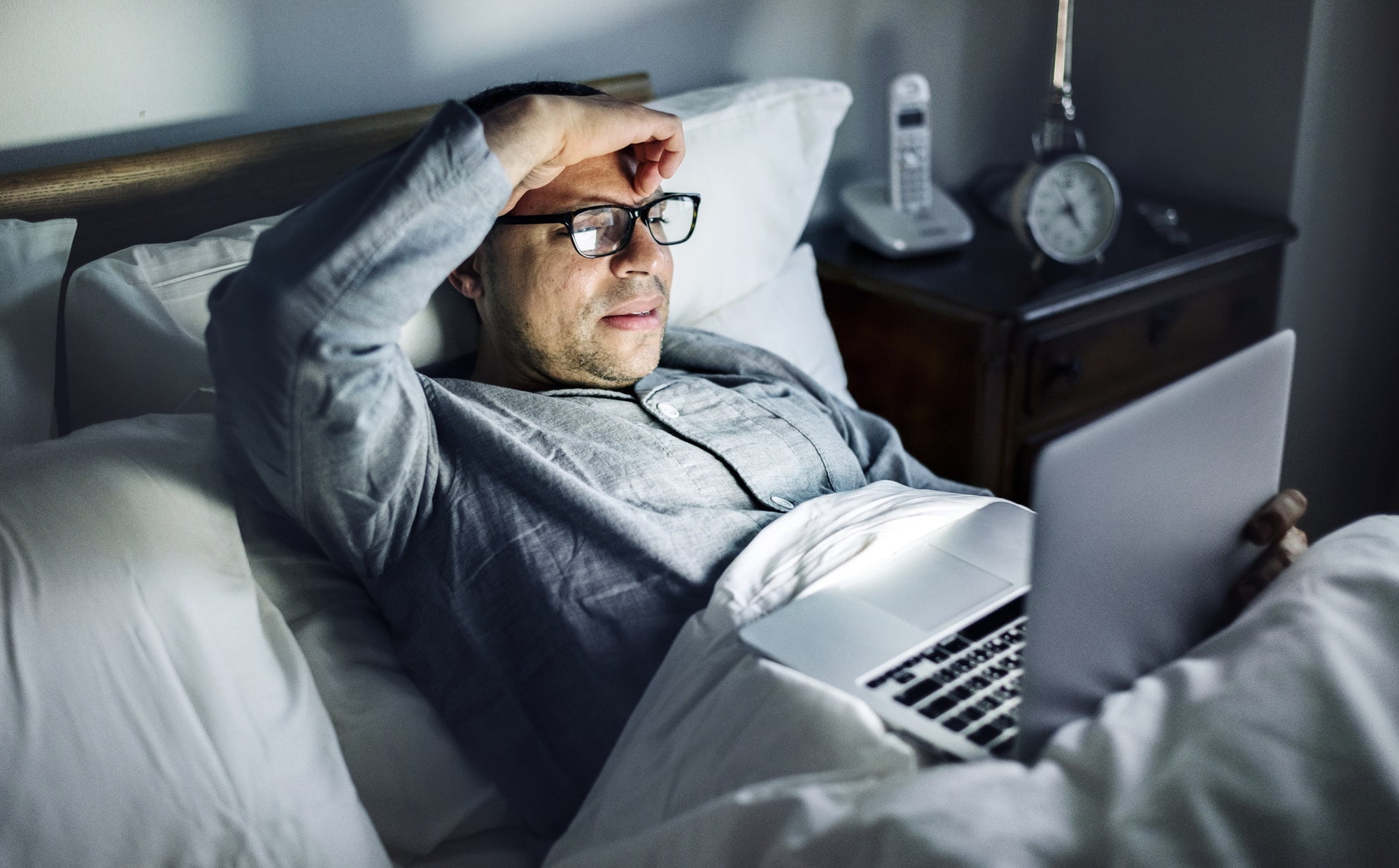 Man using laptop on a bed